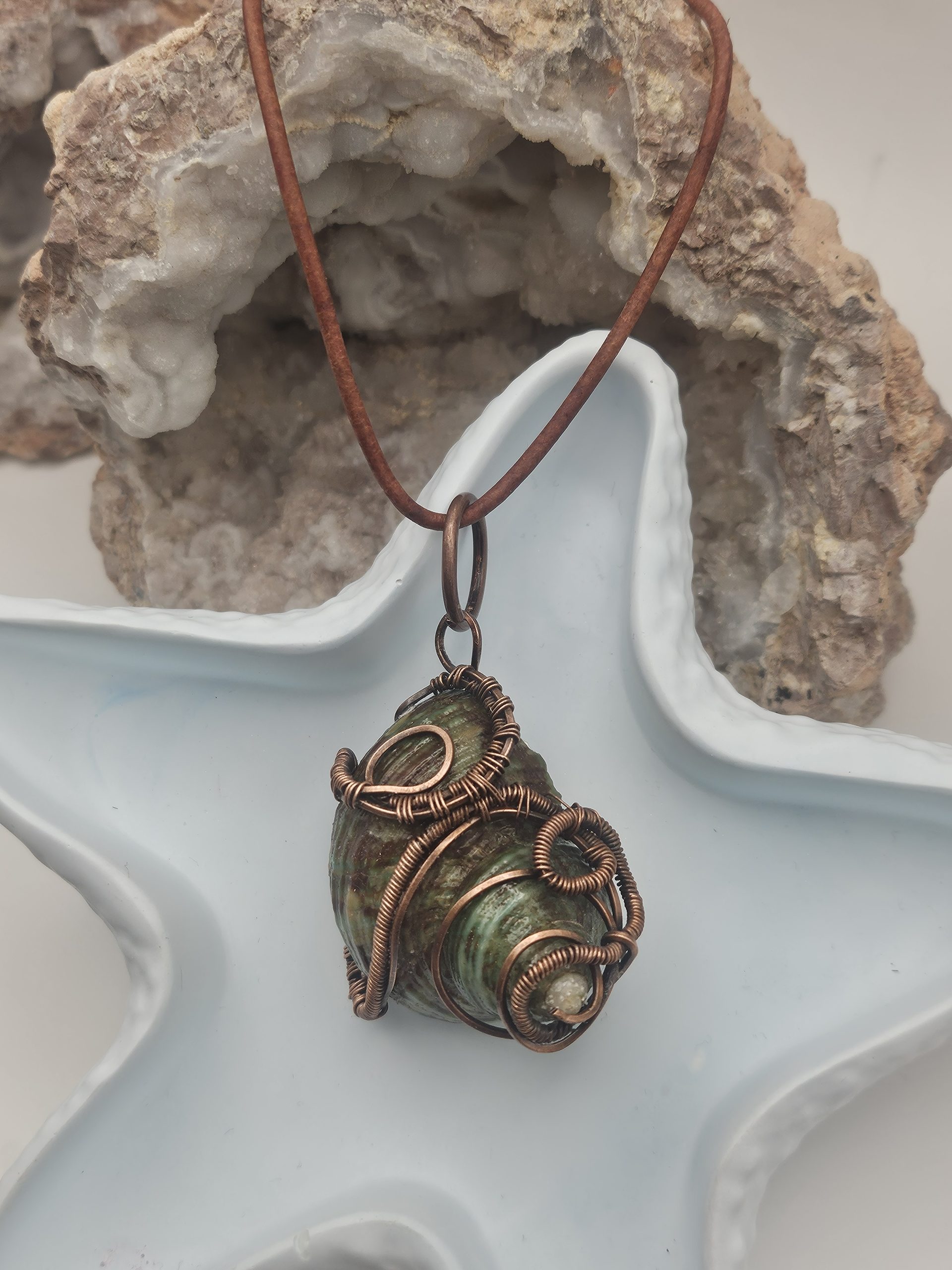 Turbinidae shell wrapped in oxidized copper wire
